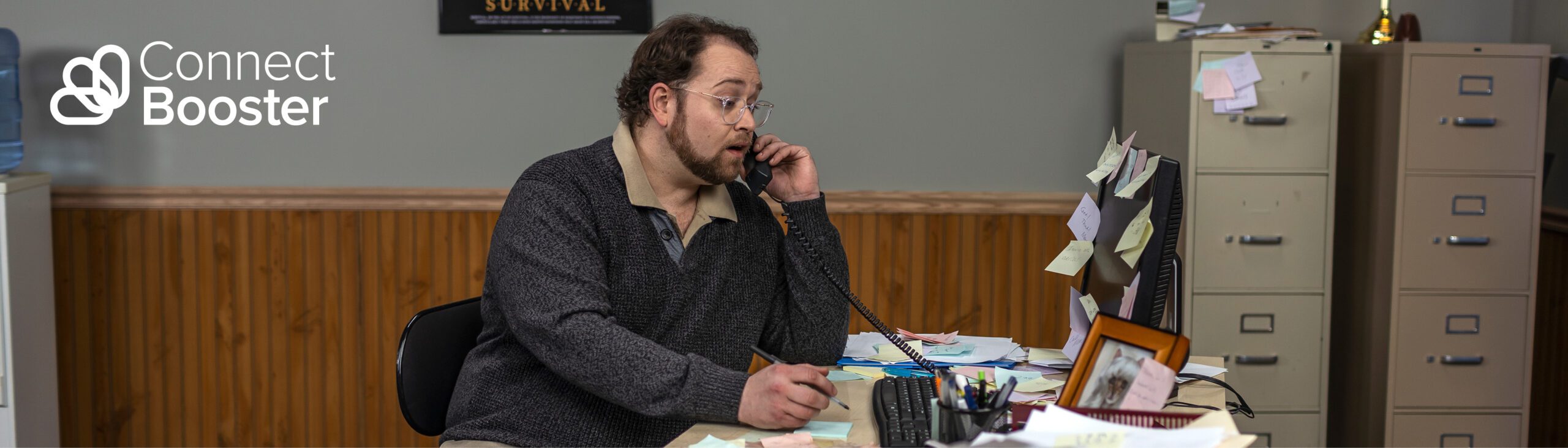 Man talks on a telephone at his desk