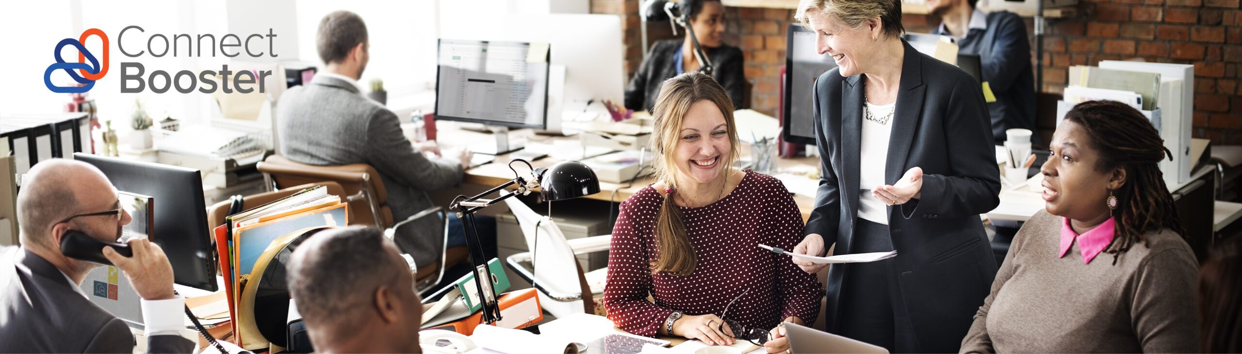 smiling people working at a messy desk